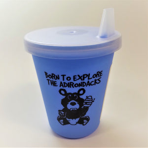 Baby blue sippy cup standing upright with clear top attached
