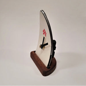 Ski tip clock in profile. Wooden base. Black and silver side with black battery area protruding from the back of the clockface.