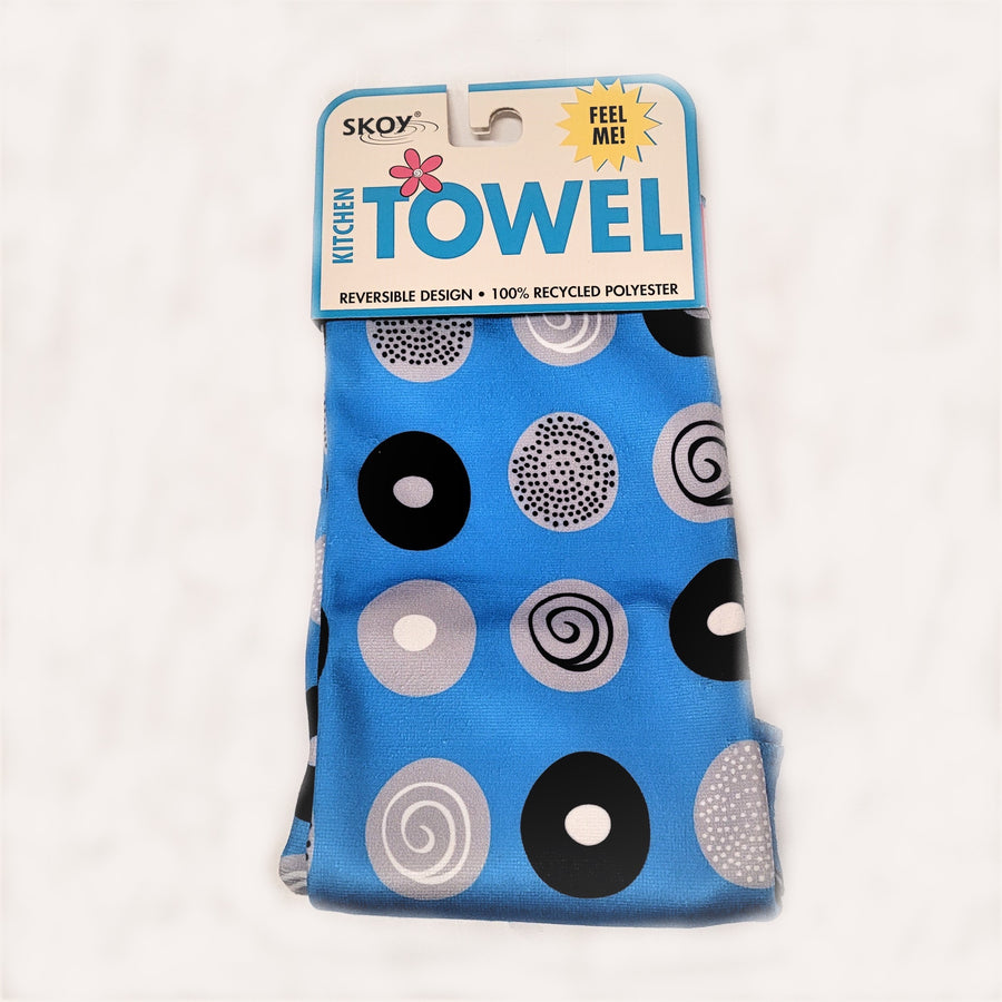 Blue Skoy dishtowel with package label on top. Circle pattern print on the solid blue colored in black, white and gray.