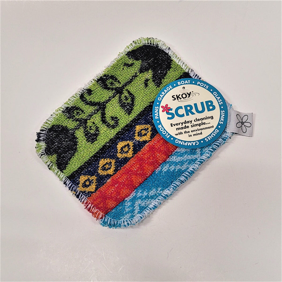 Skoy Scrub with circle label on top of a colorful scrub. Blues, reds, gold and green in vertical patterns.