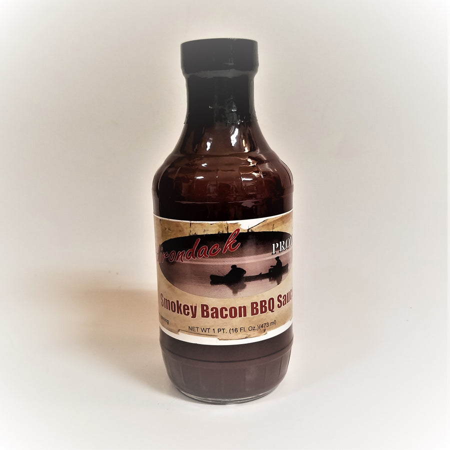 Glass bottle of Smokey Bacon BBQ Sauce. The dark, rich sauce gives the glass bottle its color under the black screw top.
