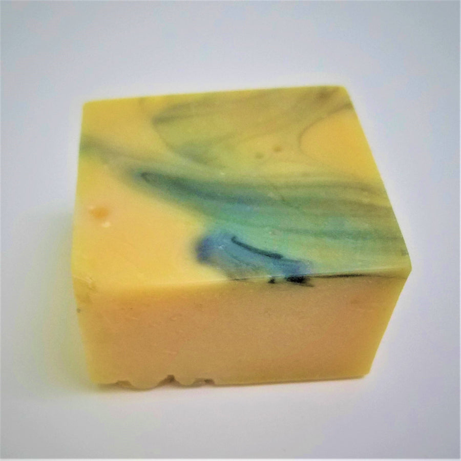 Pale yellow  square soap bar with blue marbled top.