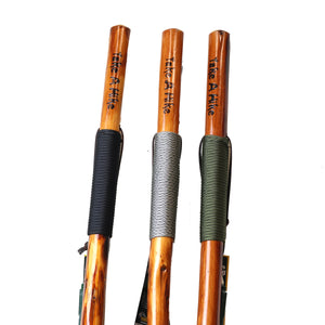 Close up of the top of the walking sticks. TAKE A HIKE lettering is seen in black top at the top of each. Black rope grip on the one furthest left; gray rope grip in the middle; and green rope grip on the right.