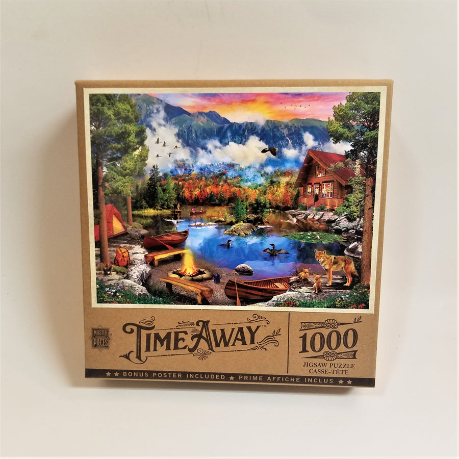 Box cover of 1000 piece jigsaw puzzle featuring bucolic setting with camp on the right, dogs in front, ducks on a lake, canoe with people on the lake, canoes docked on shore near a campfire and a red tent. Fall foliage in the background in front of majestic mountains.