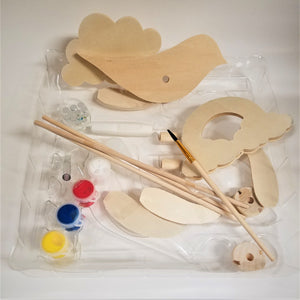 The pieces included in the kit on their plastic tray. Wooden cut outs and dowels, paint brush, 4 different paints